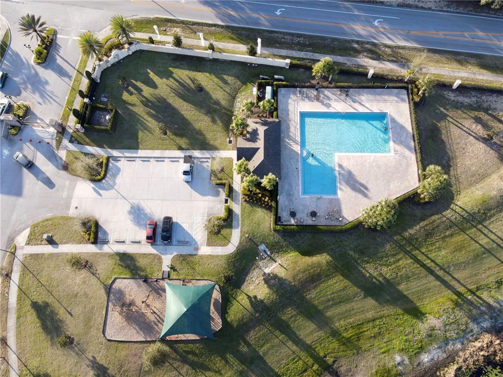 An aerial view shows a community pool, parking lot, and playground area — 124 PRIMROSE DRIVE, DAVENPORT, FL