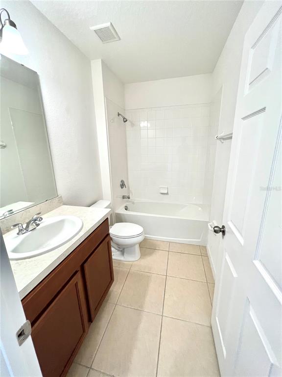 A bathroom features a vanity with a sink, a toilet, and a shower-tub combination — 124 PRIMROSE DRIVE, DAVENPORT, FL