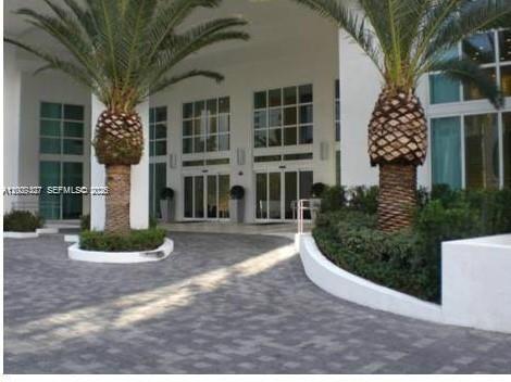 A paved driveway leads to the white building entrance flanked by two large palm trees — 951 Brickell Ave # 1808, Miami FL 33131, MIAMI, FL