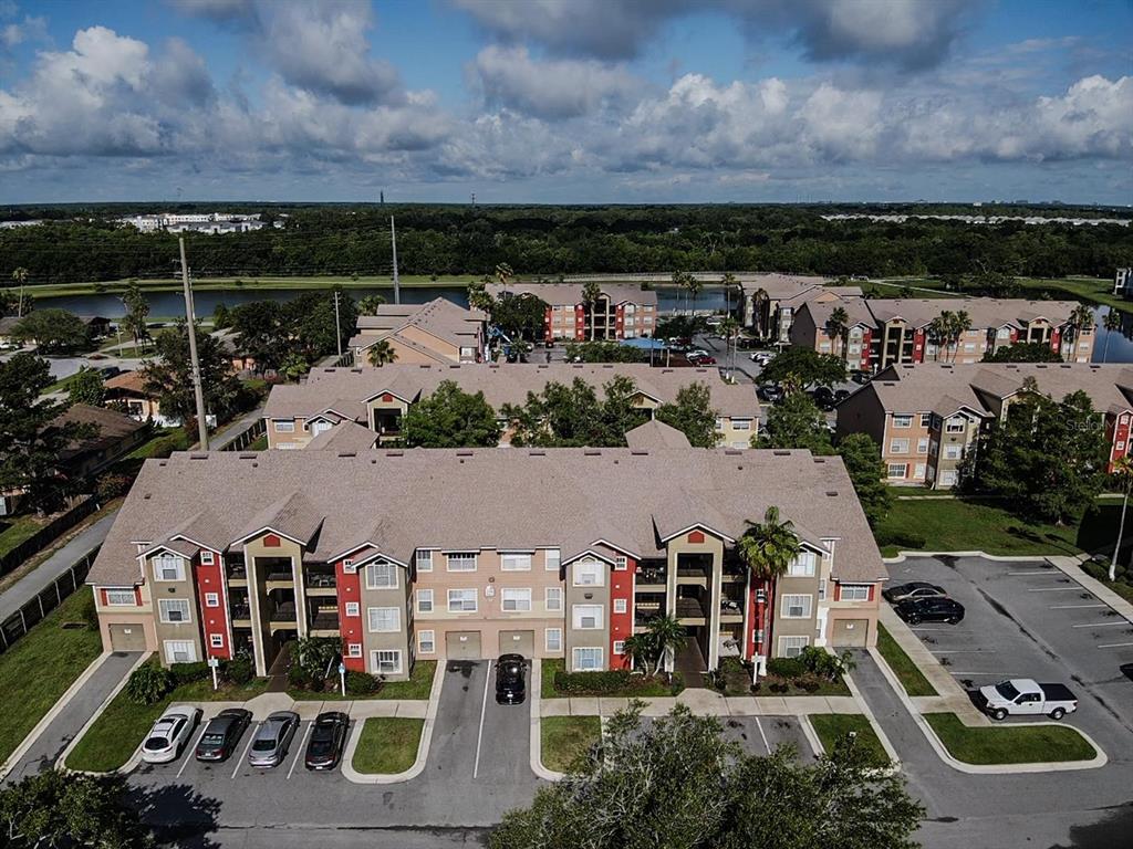 An aerial view of a multi-story apartment complex with parking lots and surrounding green space — 2208 ANTIGUA PLACE UNIT 932, KISSIMMEE, FL
