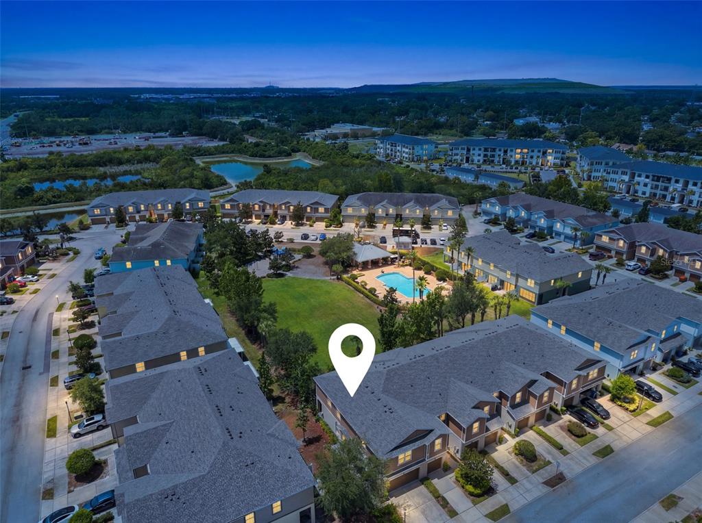 An aerial view of a residential townhouse complex featuring a central pool and green space — 8718 TURNSTONE HAVEN PLACE, TAMPA, FL