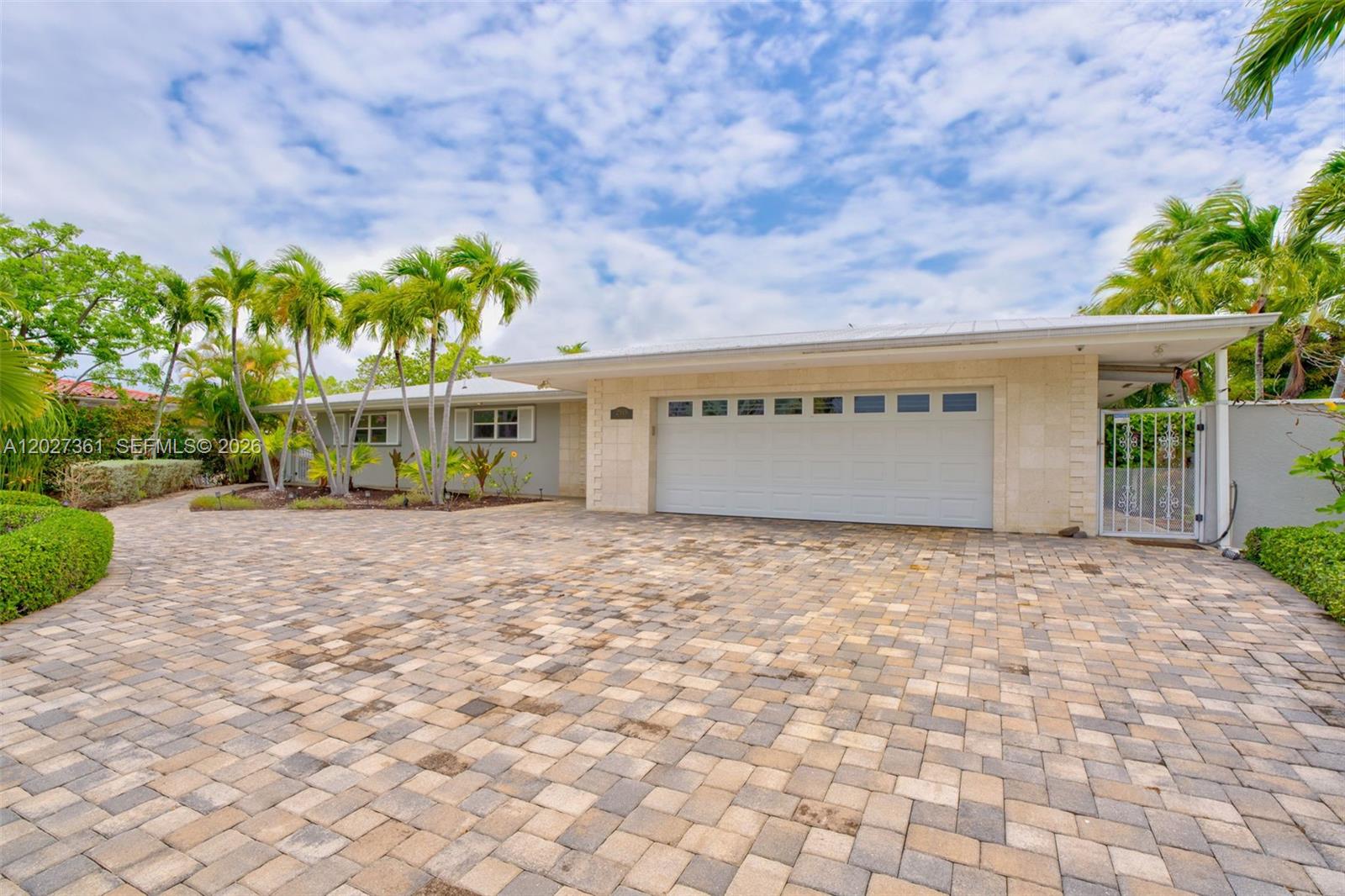 A single-story house features a paved driveway, a two-car garage, and several palm trees — 2919 Sombrero Blvd, Key Largo FL 33050, KEY LARGO, FL