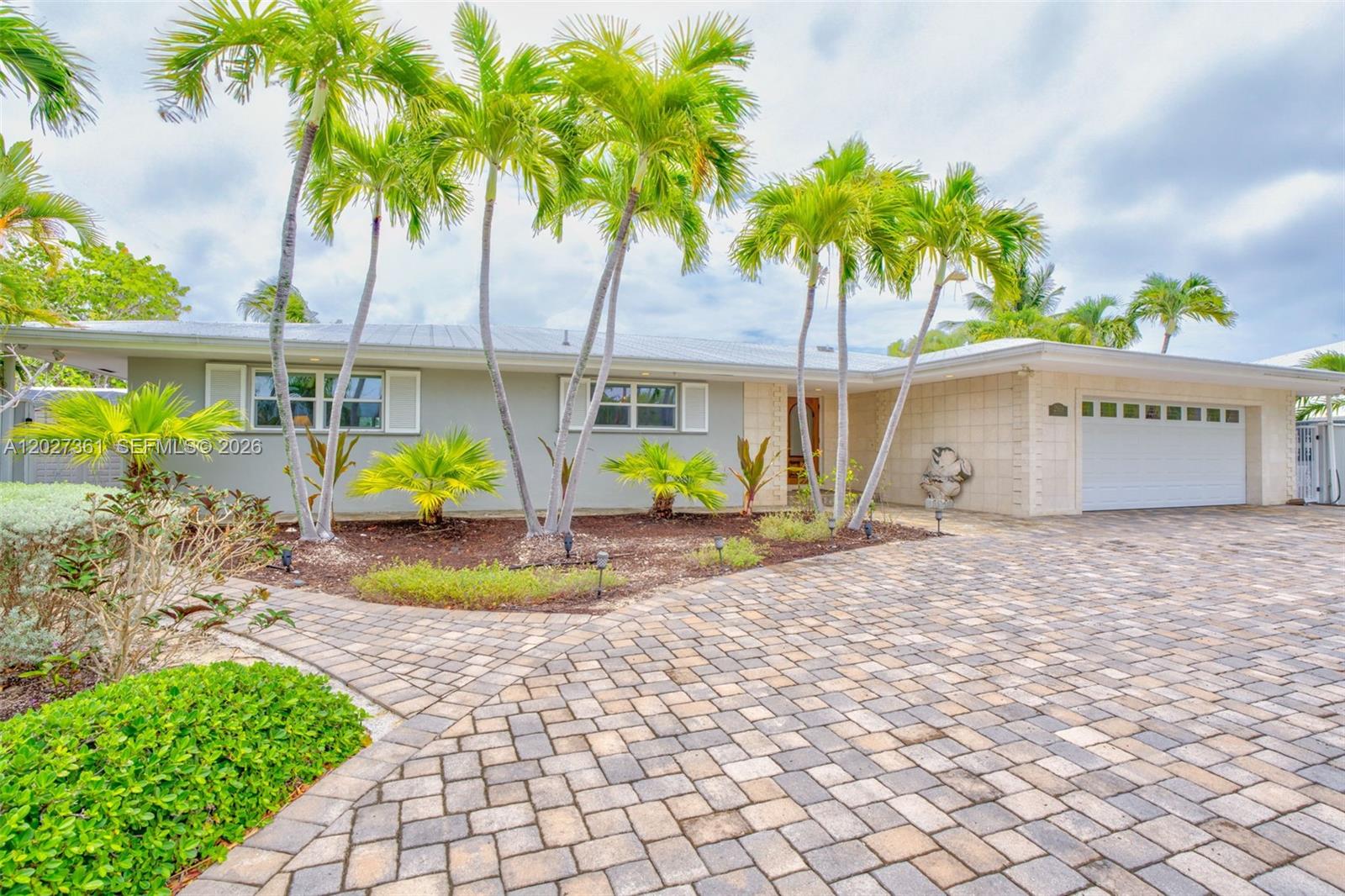 A single-story house with a paved driveway, palm trees, and a white garage door — 2919 Sombrero Blvd, Key Largo FL 33050, KEY LARGO, FL