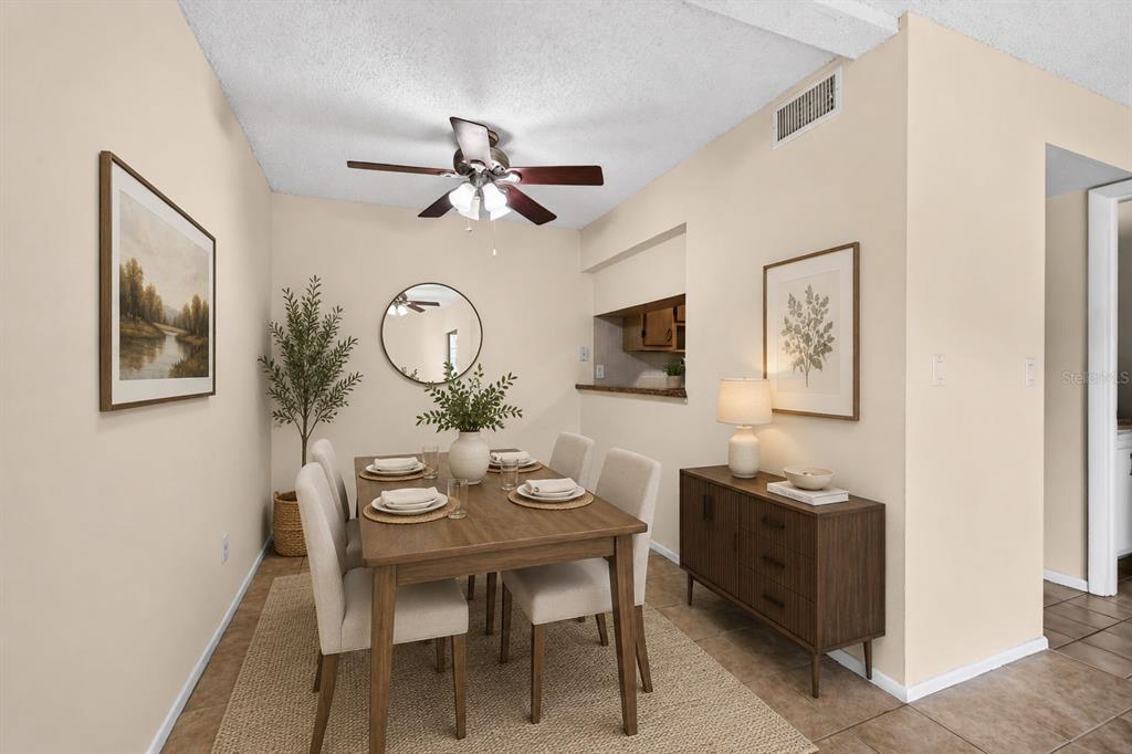 A dining room features a wooden table with four chairs, a sideboard, and wall art — 2943 LICHEN LANE UNIT B, CLEARWATER, FL