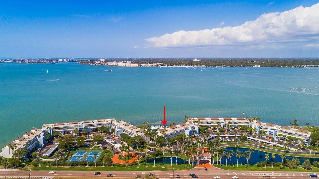 An aerial view shows a waterfront residential complex with a red arrow pointing to a unit — 5155 ISLA KEY BOULEVARD S UNIT 304, ST PETERSBURG, FL