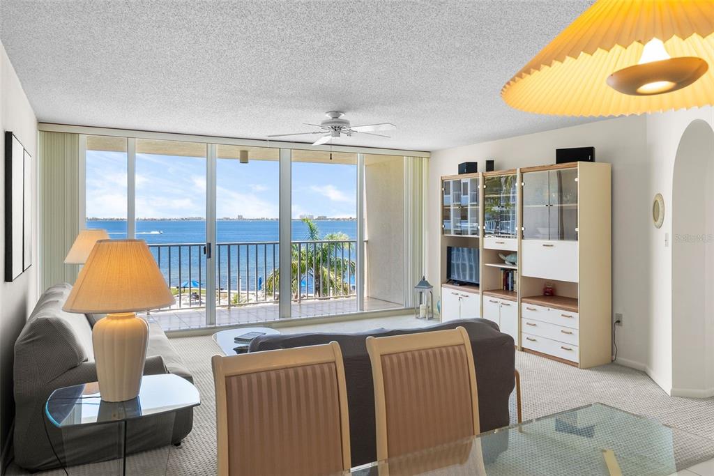 A living room with a sofa, entertainment center, and a balcony overlooking the water — 5155 ISLA KEY BOULEVARD S UNIT 304, ST PETERSBURG, FL