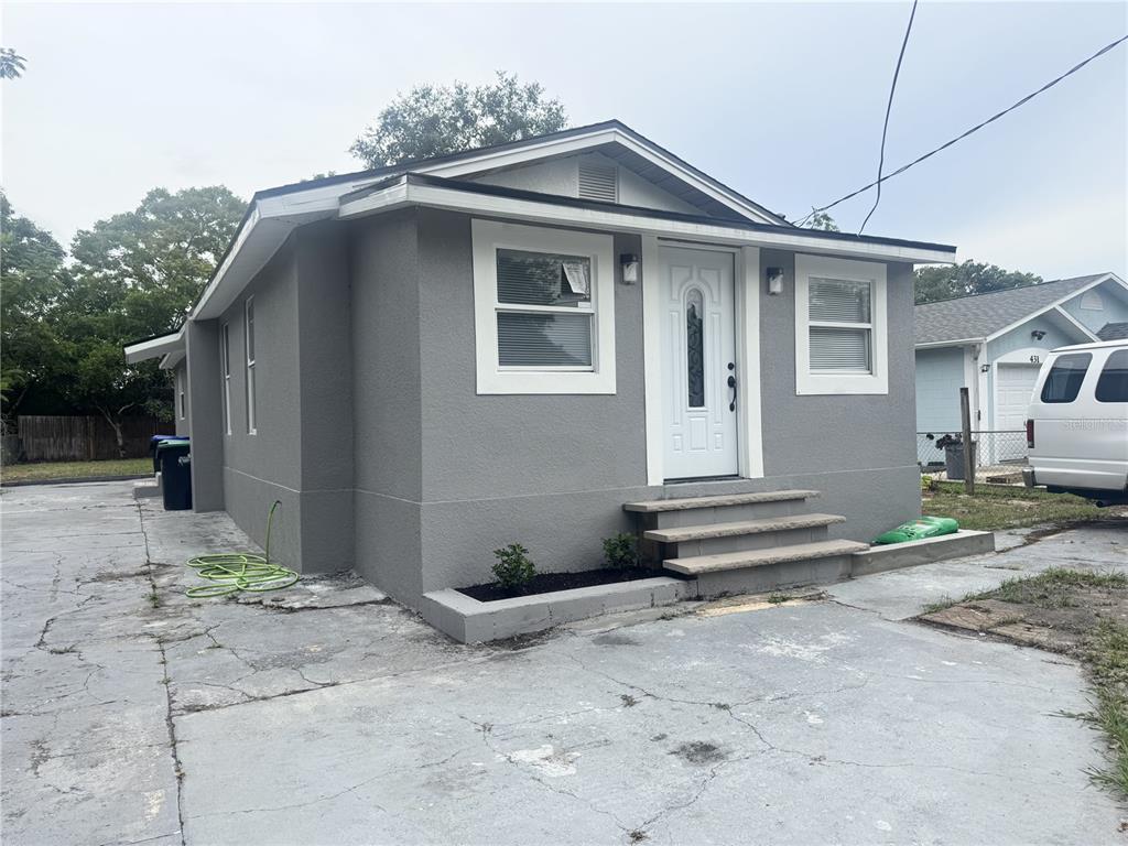 A gray, single-story house with a white front door and a concrete driveway — 425 S OBSERVATORY DRIVE, ORLANDO, FL