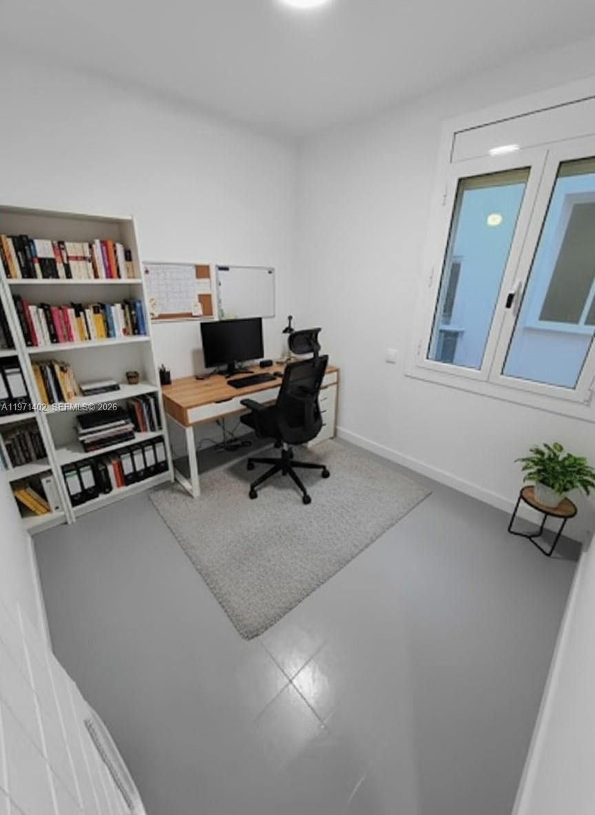 A home office features a white bookshelf, a wooden desk with a chair, and a window — Sant Antoni Maria Claret # 77, NJ 08025, NJ