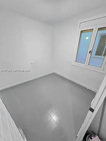 An empty room with white walls, gray flooring, and a single window — Sant Antoni Maria Claret # 77, NJ 08025, NJ