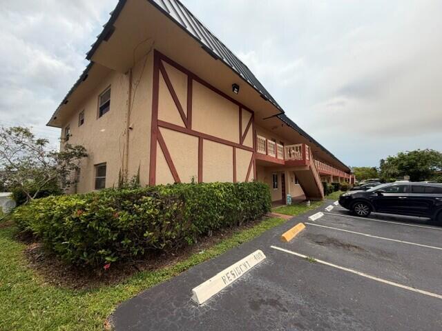 A low-angle exterior view of a two-story apartment building with a parking lot — 9272 SW 3rd Street # 409, Boca Raton FL 33428, BOCA RATON, FL