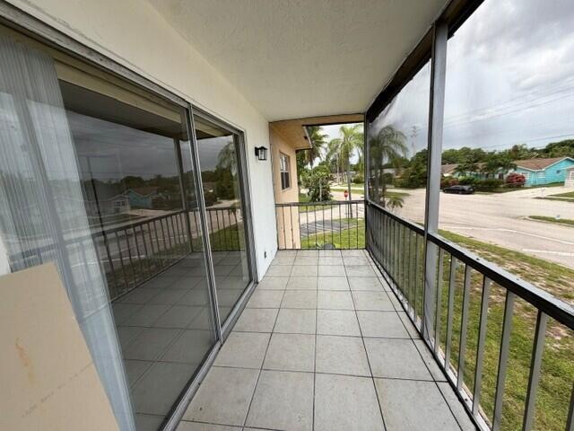 A screened-in balcony features light-colored tile flooring and sliding glass doors — 9272 SW 3rd Street # 409, Boca Raton FL 33428, BOCA RATON, FL