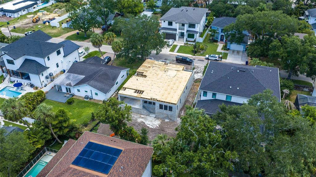 An aerial view shows a residential neighborhood featuring a house under construction with exposed framing — 4506 W MELROSE AVENUE, TAMPA, FL