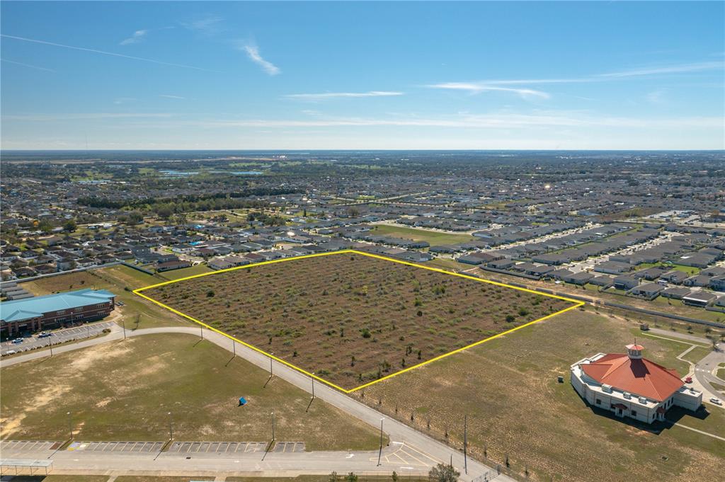 An aerial view shows a vacant rectangular lot outlined in yellow near suburban houses — 0 ORCHID DRIVE, HAINES CITY, FL