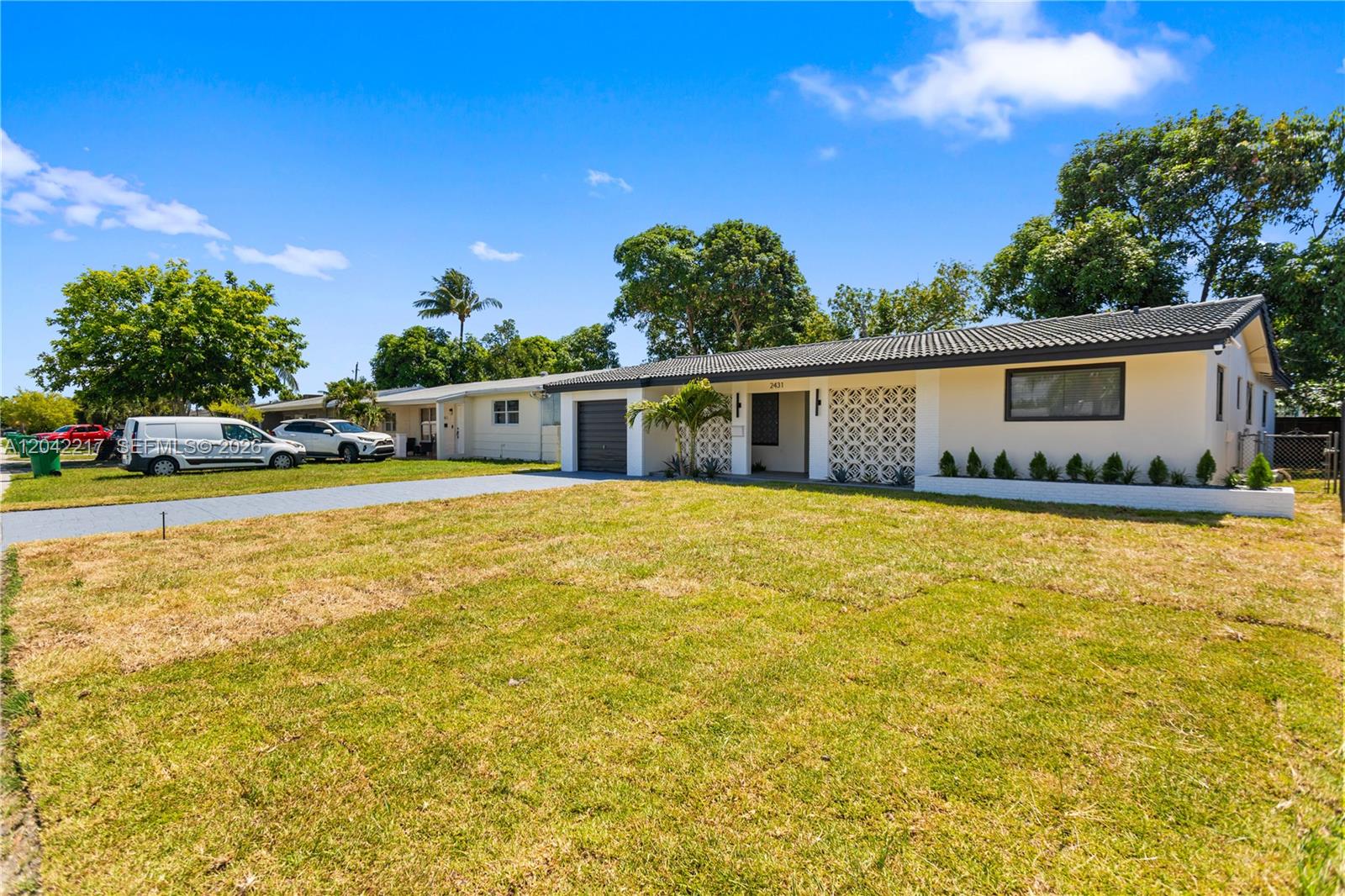 A single-story house with a white facade, decorative screen wall, and a gray-tiled roof — 2431 Sabal Palm Dr, Miramar FL 33023, MIRAMAR, FL