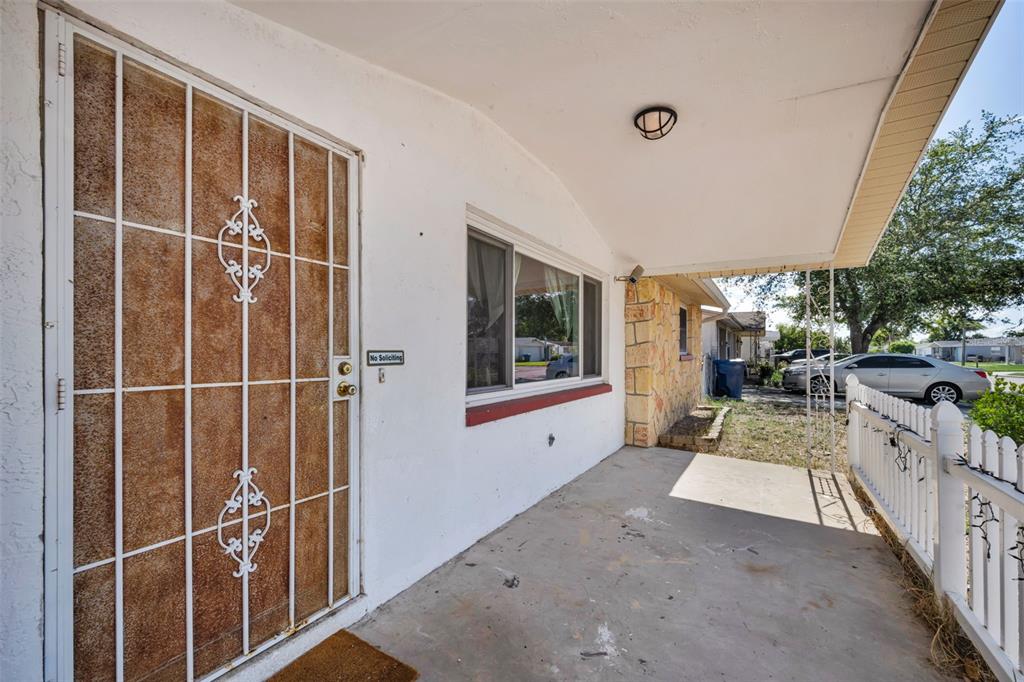 A single-story house with a stone facade, a white picket fence, and a covered porch — 3541 BIGELOW DRIVE, HOLIDAY, FL