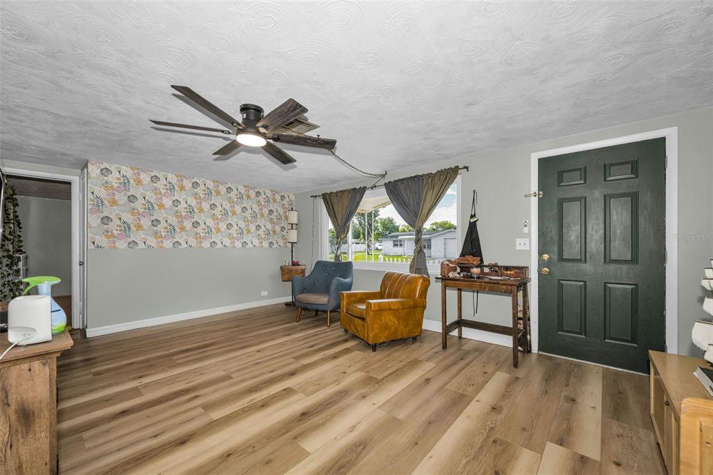 A covered concrete porch features a white security door and a white picket fence — 3541 BIGELOW DRIVE, HOLIDAY, FL