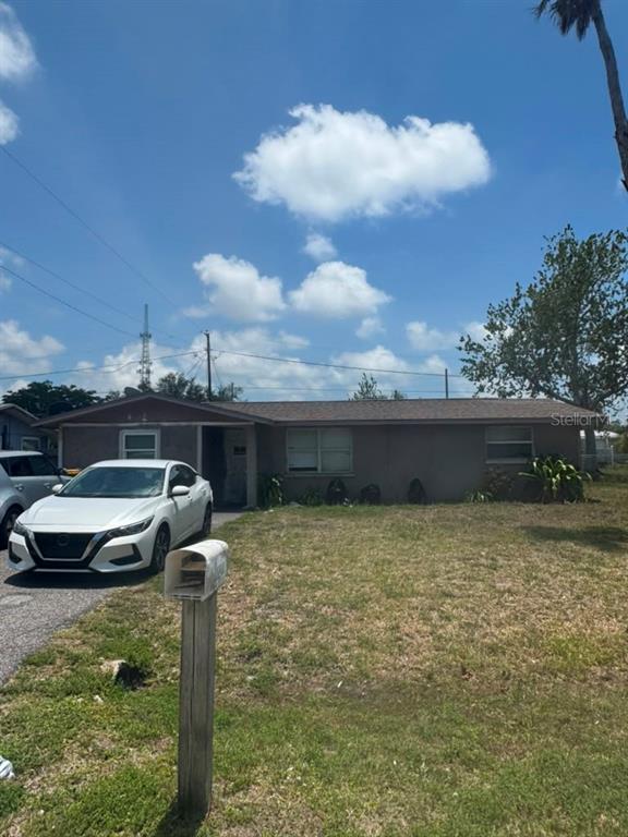 A single-story house with a brown exterior, a white car parked in front, and a mailbox — 8289 PELICAN ROAD, ENGLEWOOD, FL