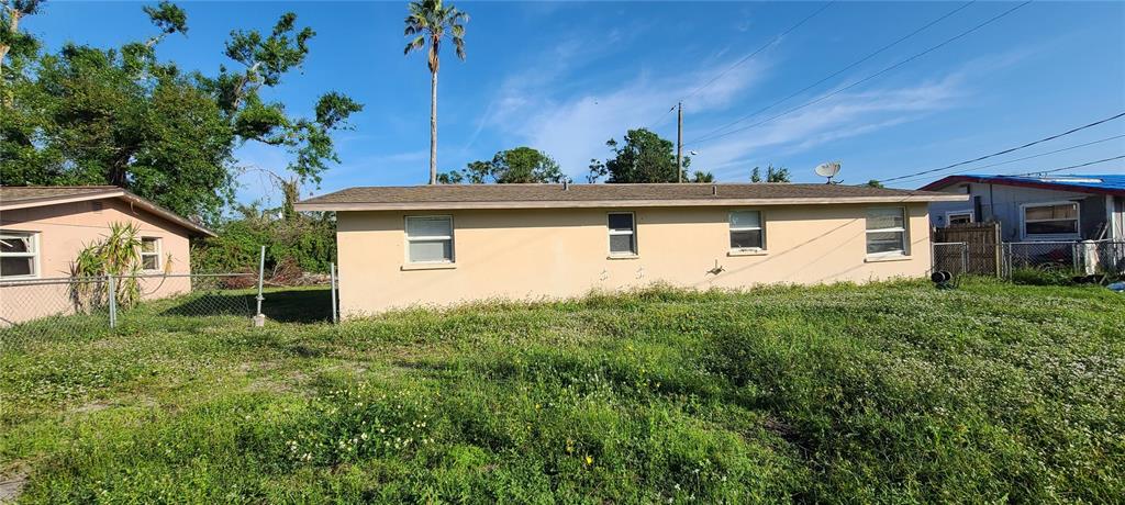 The exterior of a single-story tan house with a brown roof and overgrown lawn — 8289 PELICAN ROAD, ENGLEWOOD, FL