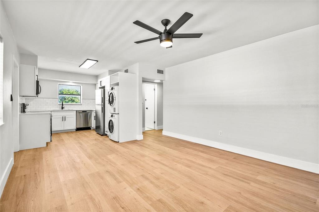 A bright, open-concept kitchen and living area featuring light wood flooring and a ceiling fan — 300 S NIMBUS AVENUE UNIT 6, CLEARWATER, FL