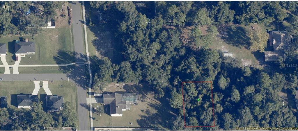 An aerial view shows a wooded residential lot outlined in red next to existing homes — 240 W ELM DRIVE, ORANGE CITY, FL