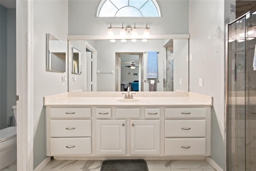 A bathroom features a white double vanity with a large mirror and a light fixture — 500 NE 52ND COURT, OCALA, FL