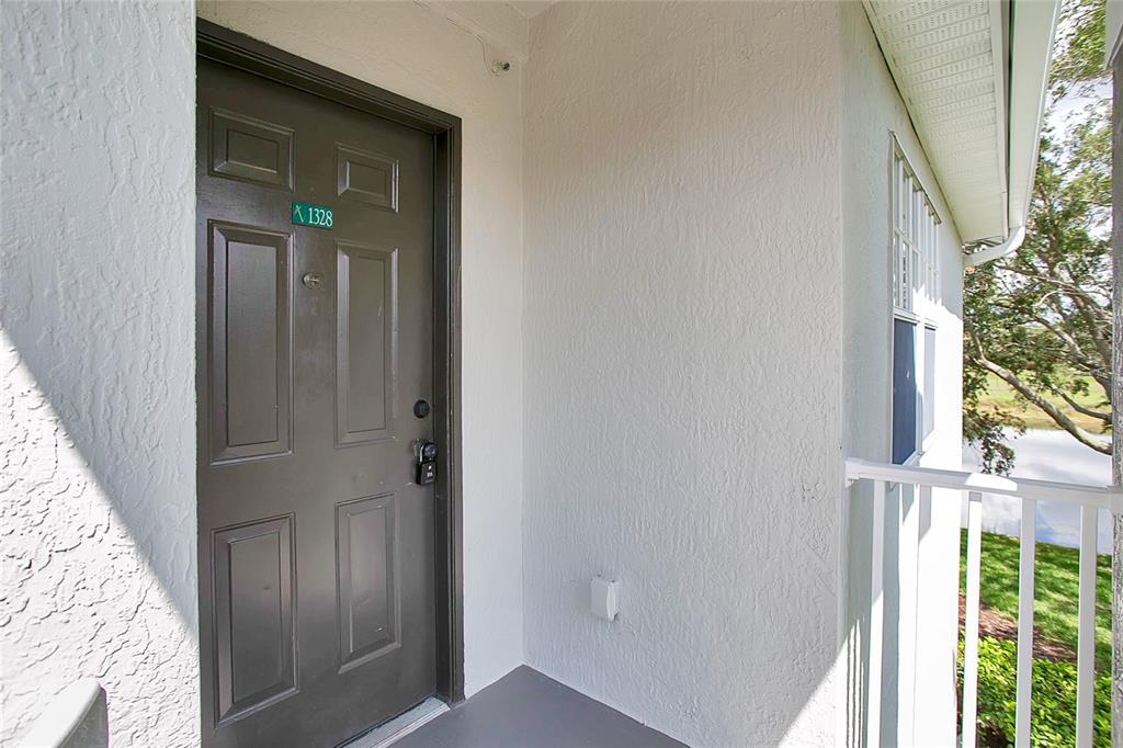 A brown front door with a unit number is set in a white stucco wall — 13815 FAIRWAY ISLAND DRIVE UNIT 1328, ORLANDO, FL