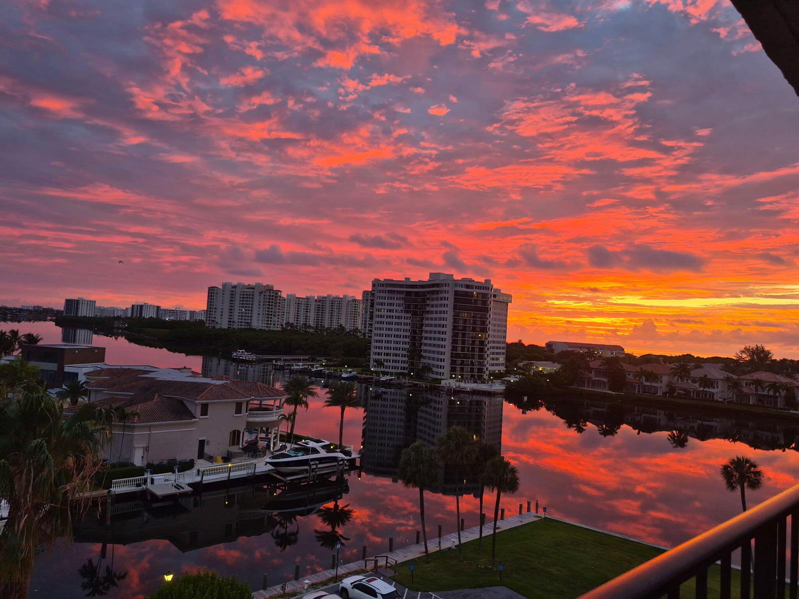 A high-angle view shows a waterfront residential area during a vibrant, colorful sunset — 899 Jeffery Street # 710, Boca Raton FL 33487, BOCA RATON, FL