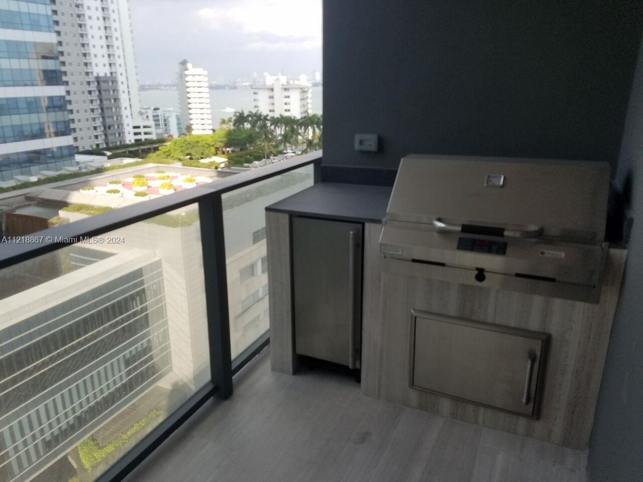 A balcony features a built-in stainless steel grill and a small refrigerator — 1451 Brickell Ave # 1206, Miami FL 33131, MIAMI, FL