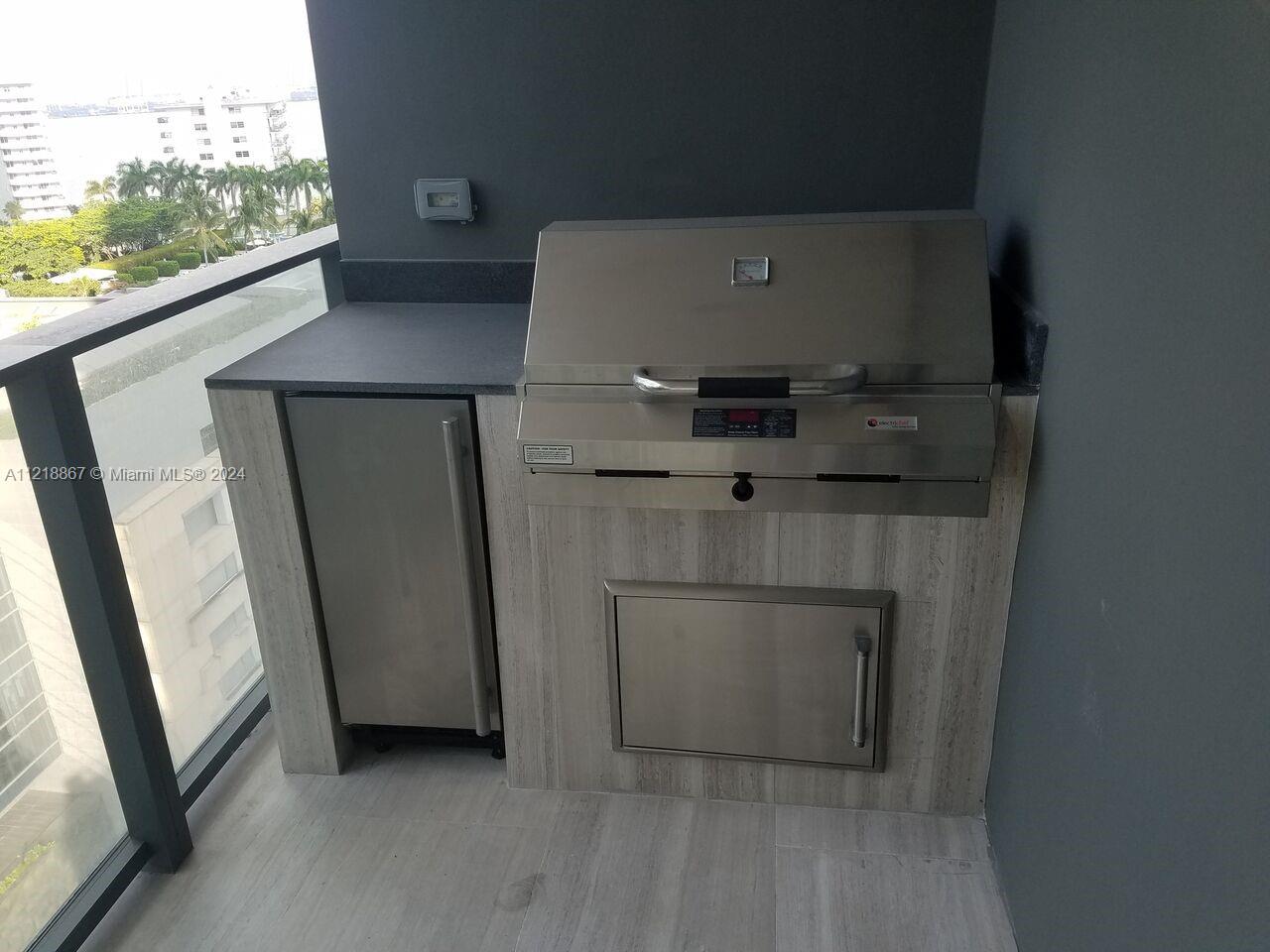 A stainless steel outdoor grill and cabinet are built into a stone-topped balcony counter — 1451 Brickell Ave # 1206, Miami FL 33131, MIAMI, FL