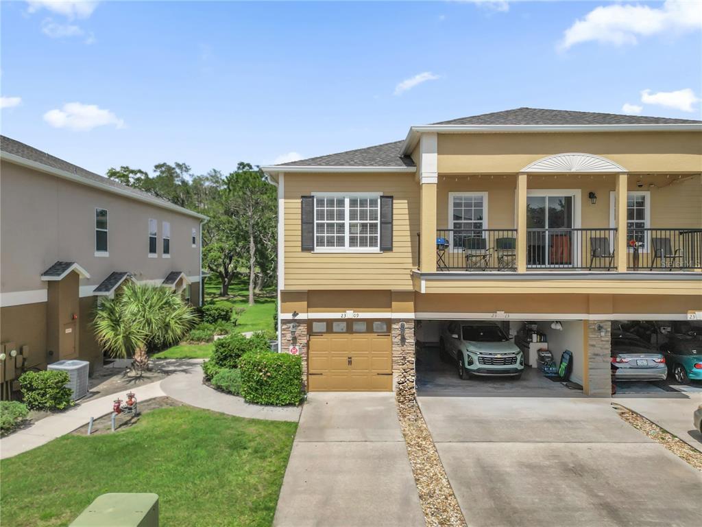 An exterior view of a two-story townhouse with a garage and a second-floor balcony — 2309 BETSY ROSS LANE UNIT 2309, ST CLOUD, FL