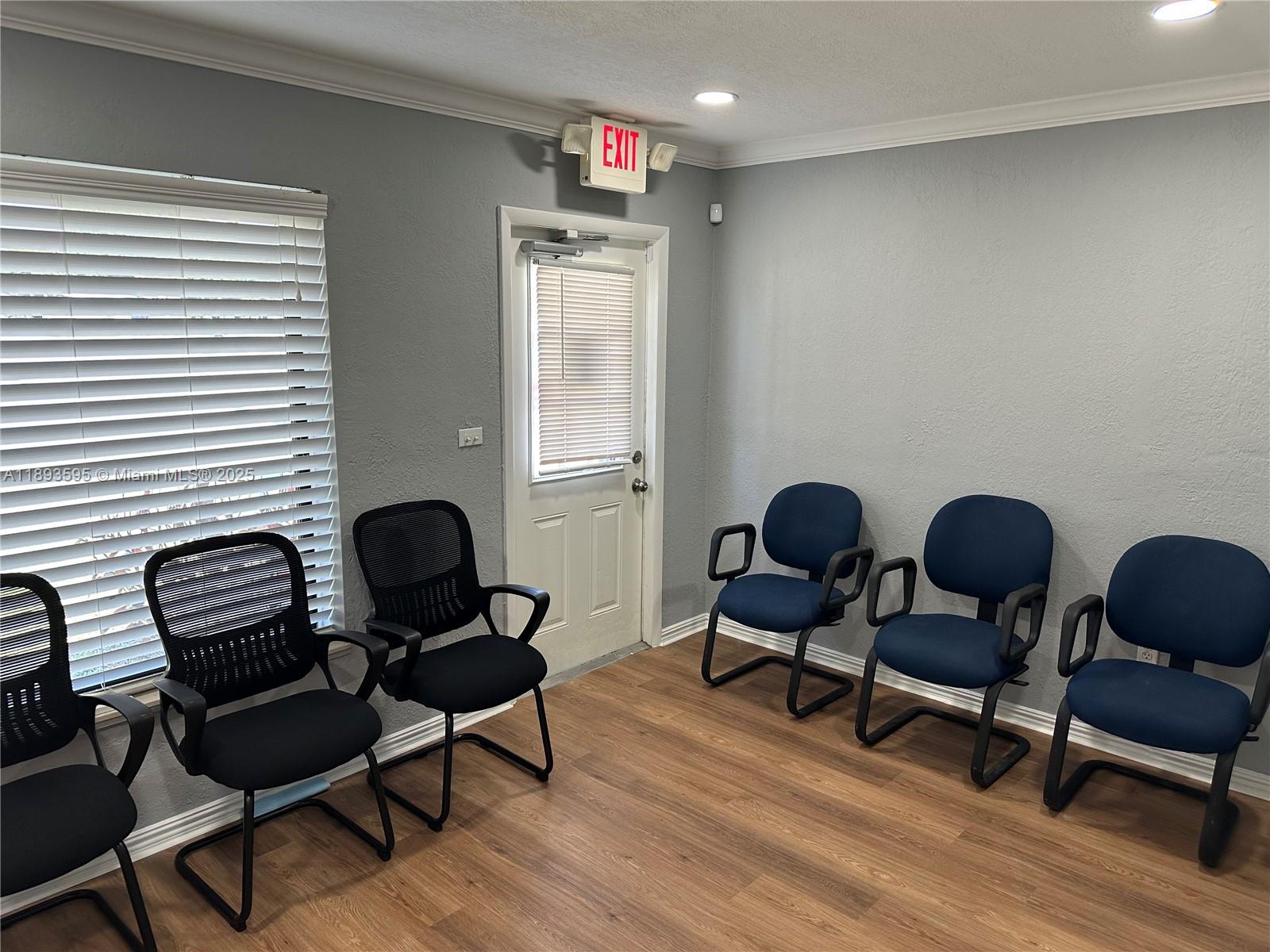 A medical examination room features a pink exam table, a blue supply cart, and an IV pole — 7070 Taft St, Hollywood FL 33024, HOLLYWOOD, FL