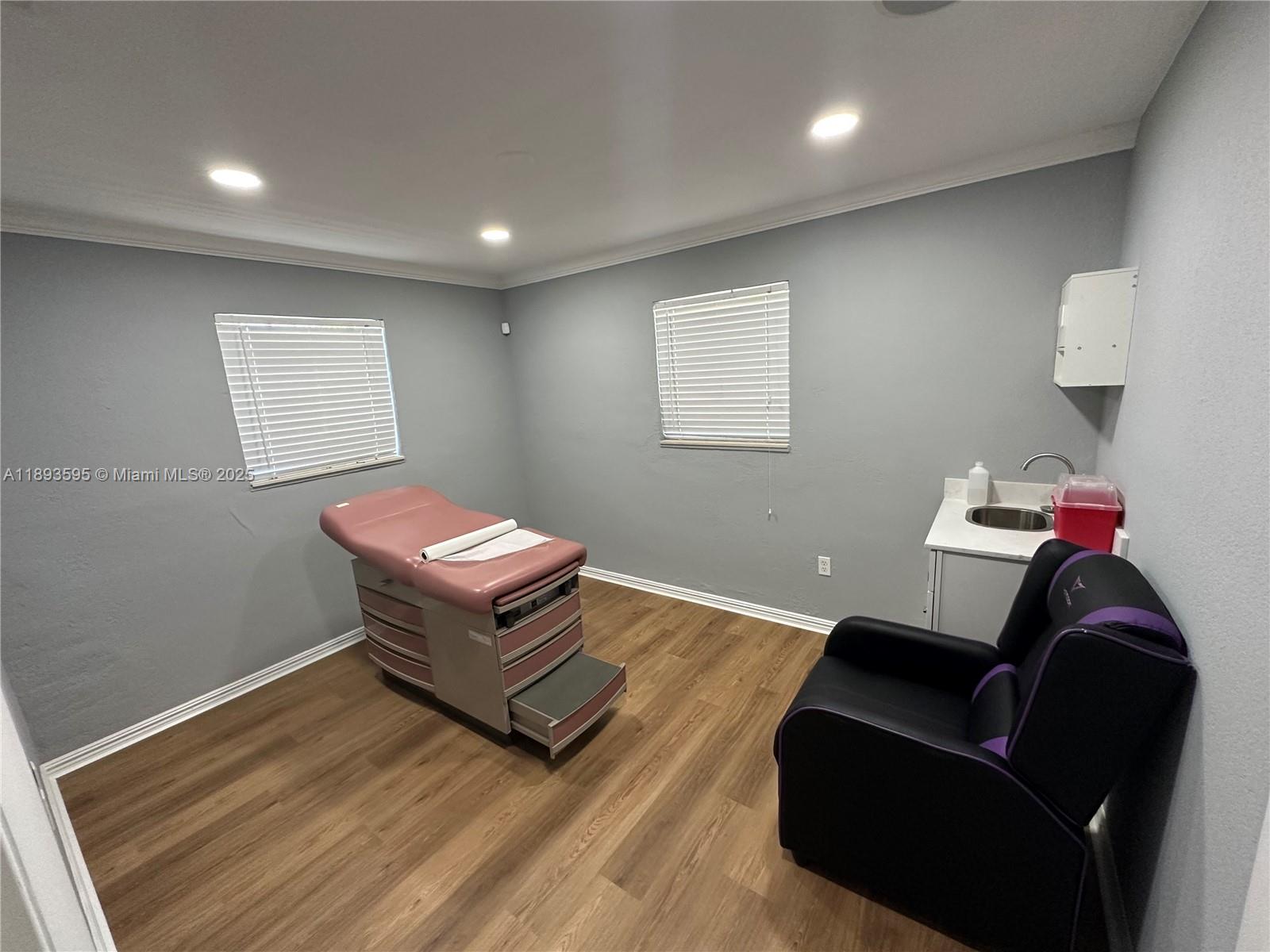 A waiting room features gray walls, wood-look flooring, a white door, and five office chairs — 7070 Taft St, Hollywood FL 33024, HOLLYWOOD, FL