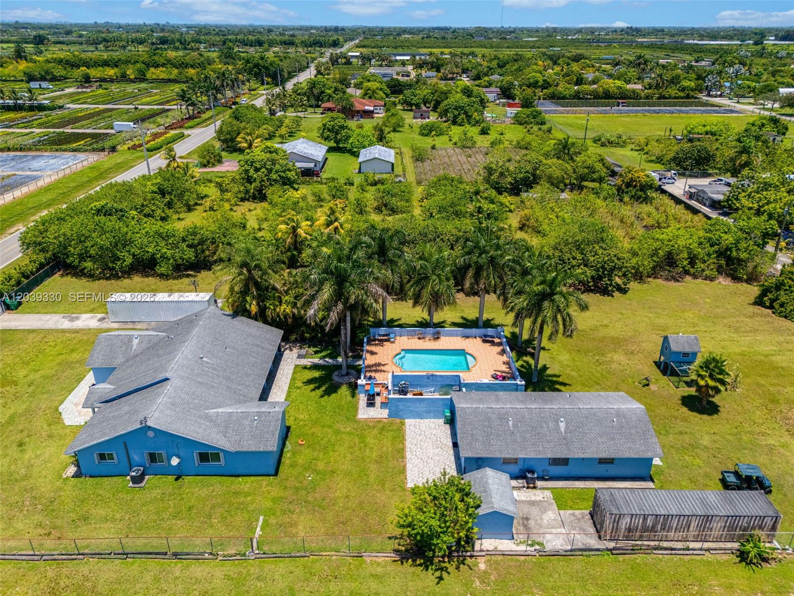 An aerial view shows two blue houses with a central swimming pool and palm trees — 20950 SW 232nd St, Miami FL 33170, MIAMI, FL