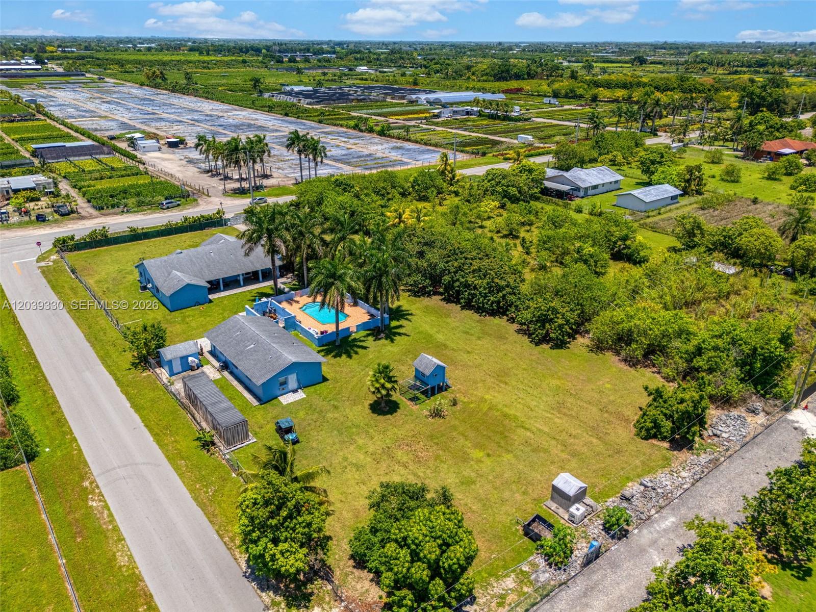 An aerial view shows a blue house with a pool and outbuildings on a large lot — 20950 SW 232nd St, Miami FL 33170, MIAMI, FL