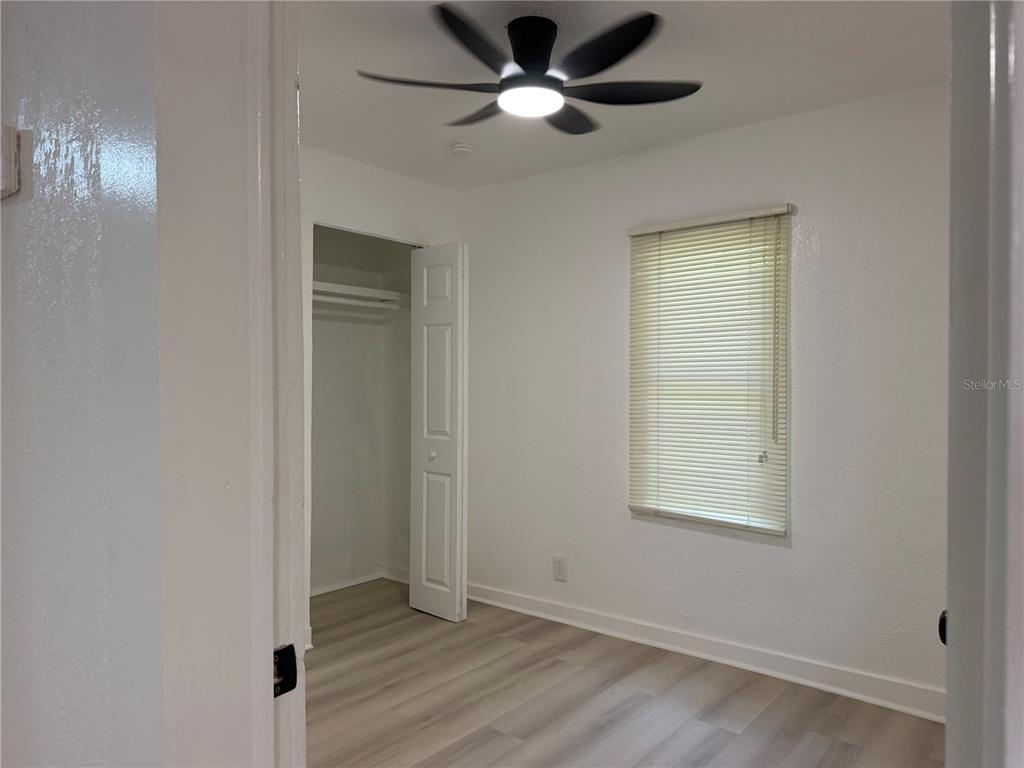 A bedroom with white walls, light wood-look flooring, a ceiling fan, and a closet — 3403 LINDELL AVENUE, TAMPA, FL