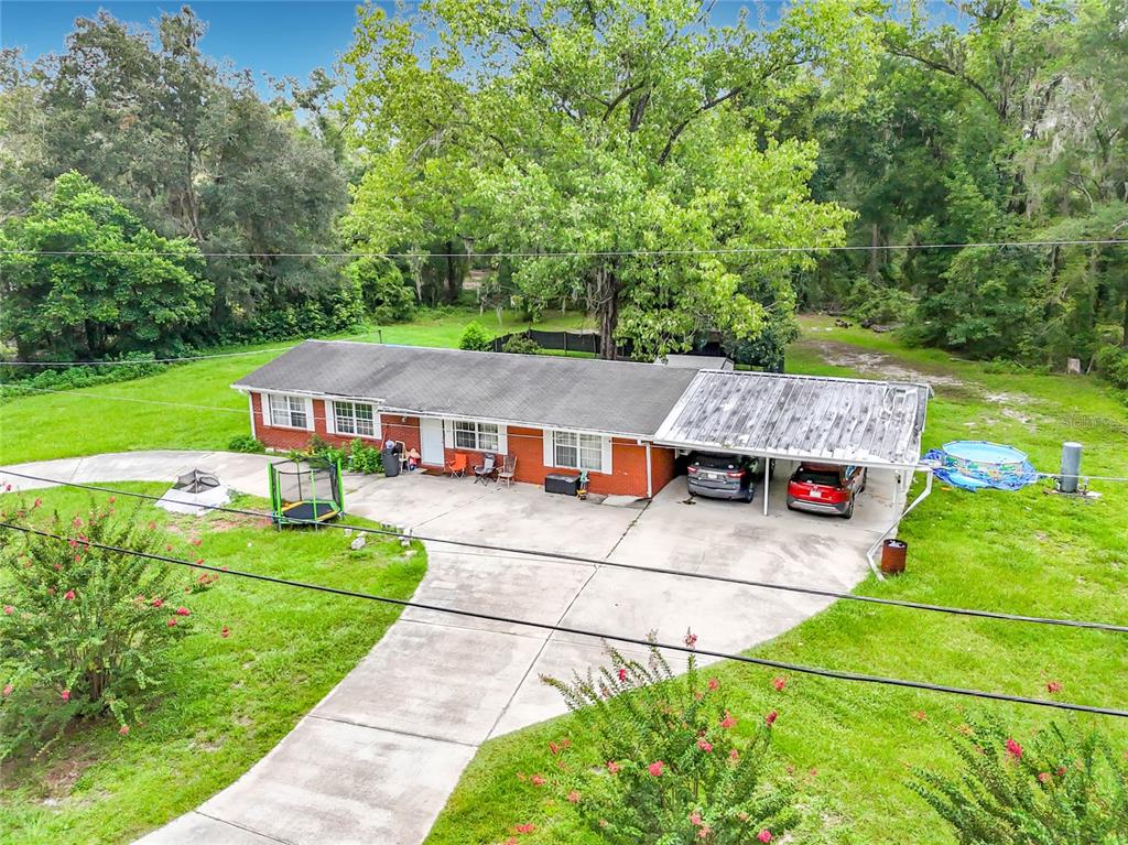 An aerial view of a single-story brick house with a carport and a large yard — 173 SE ANDREWS DRIVE, LAKE CITY, FL
