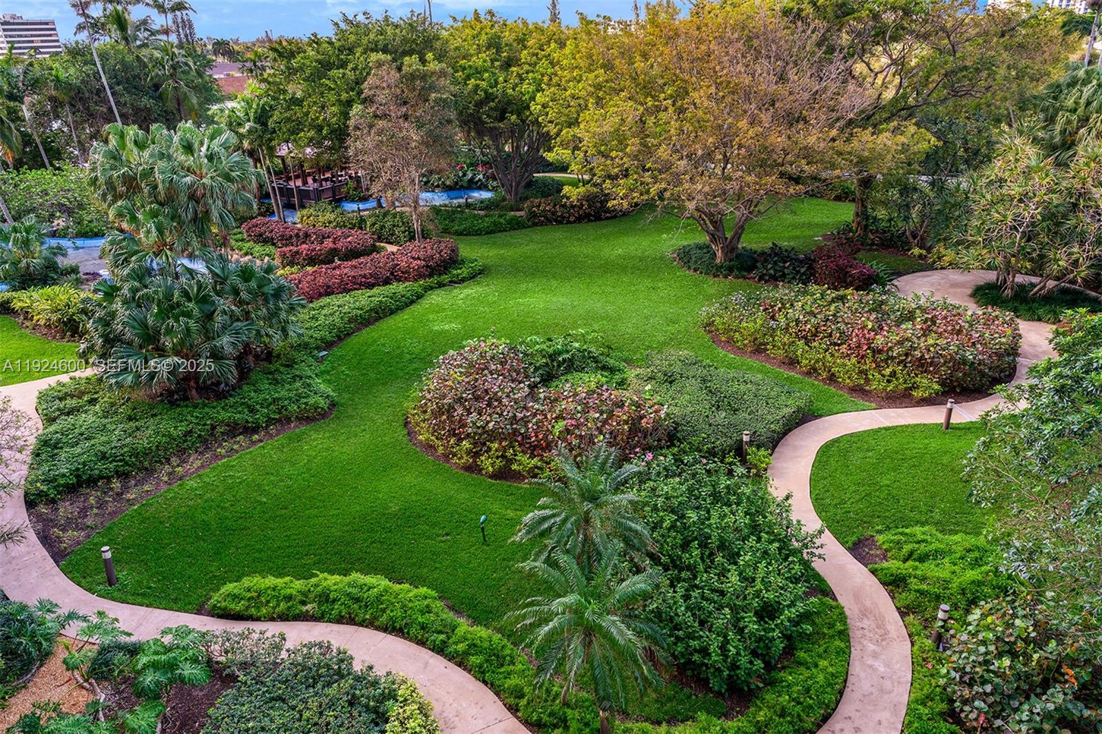 An aerial view shows a landscaped garden with winding concrete paths, green lawns, and trees — 4000 Towerside Ter # 705, Miami FL 33138, MIAMI, FL