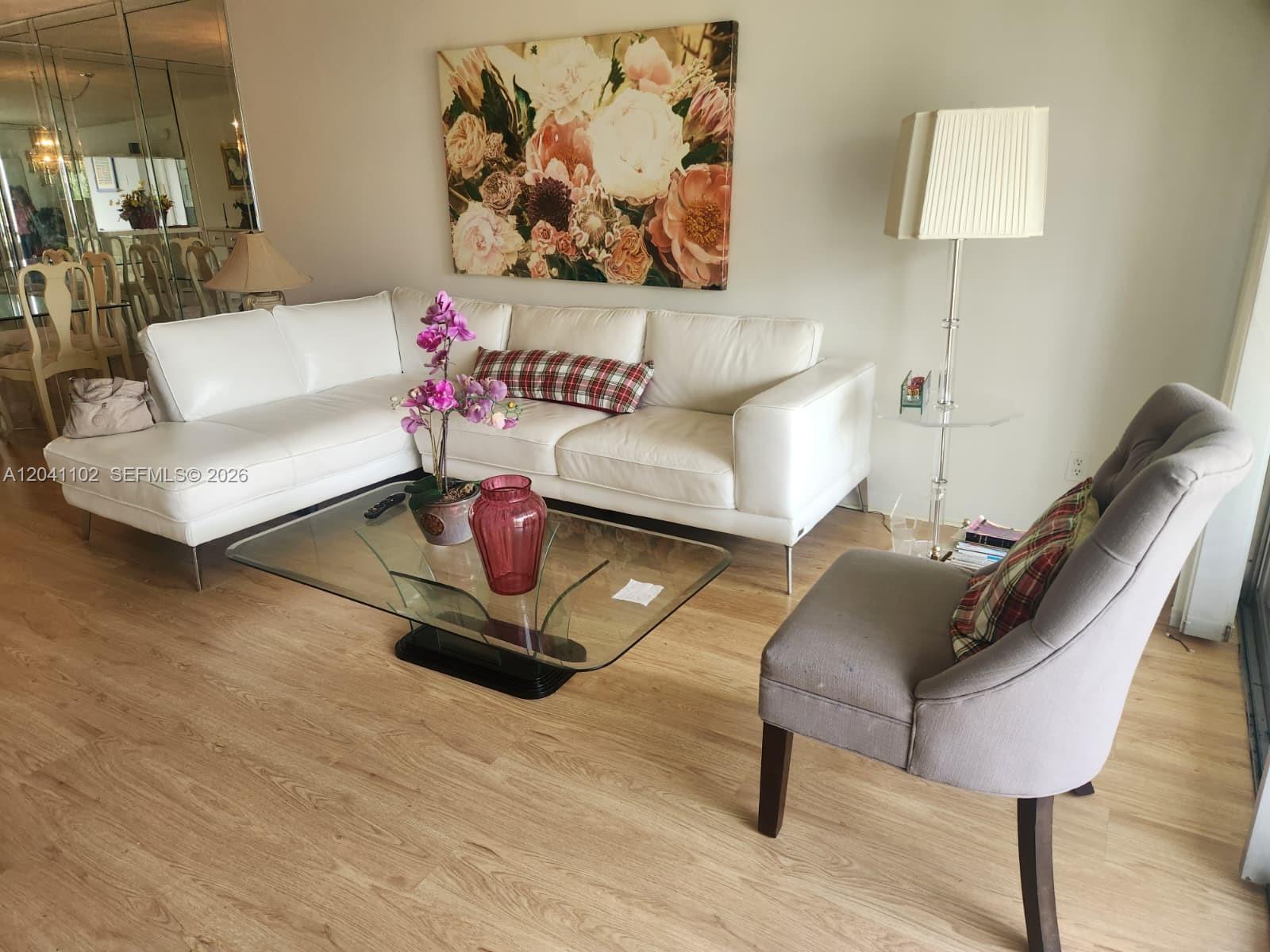 A living room features a white sectional sofa, a glass coffee table, and a gray chair — 3571 Inverrary Dr # 307, Lauderhill FL 33319, LAUDERHILL, FL