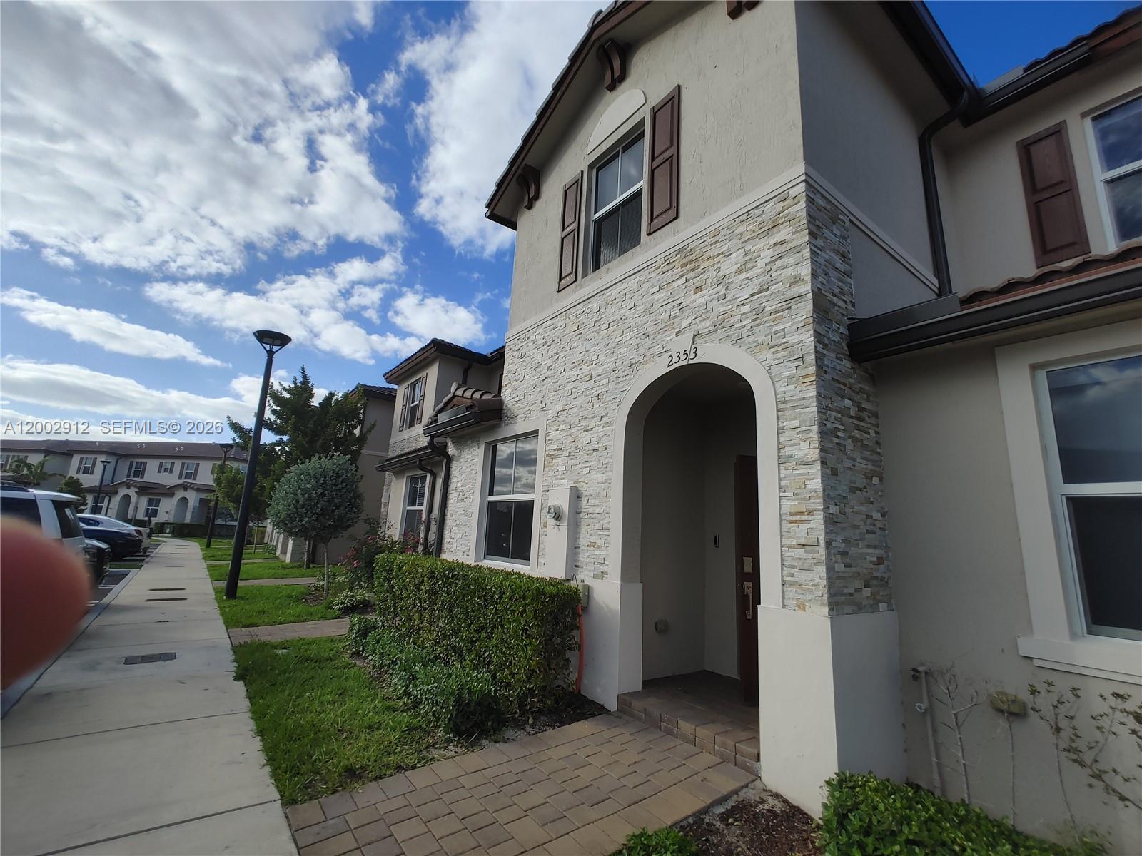 A two-story residential building features a stone-veneer entryway and a paved walkway — 2353 NW 122nd Ter # 0, Miami FL 33167, MIAMI, FL