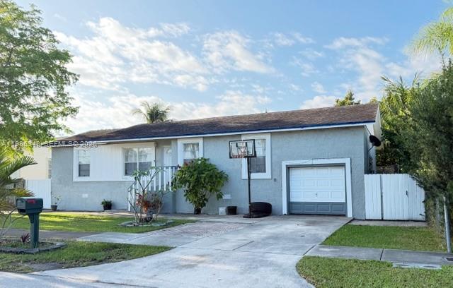 A single-story house with a gray exterior, a small garage, and a basketball hoop in front — 9770 SW 210th St, Cutler Bay FL 33189, CUTLER BAY, FL