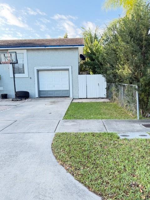 A light blue house features a single-car garage, a basketball hoop, and a white fence — 9770 SW 210th St, Cutler Bay FL 33189, CUTLER BAY, FL
