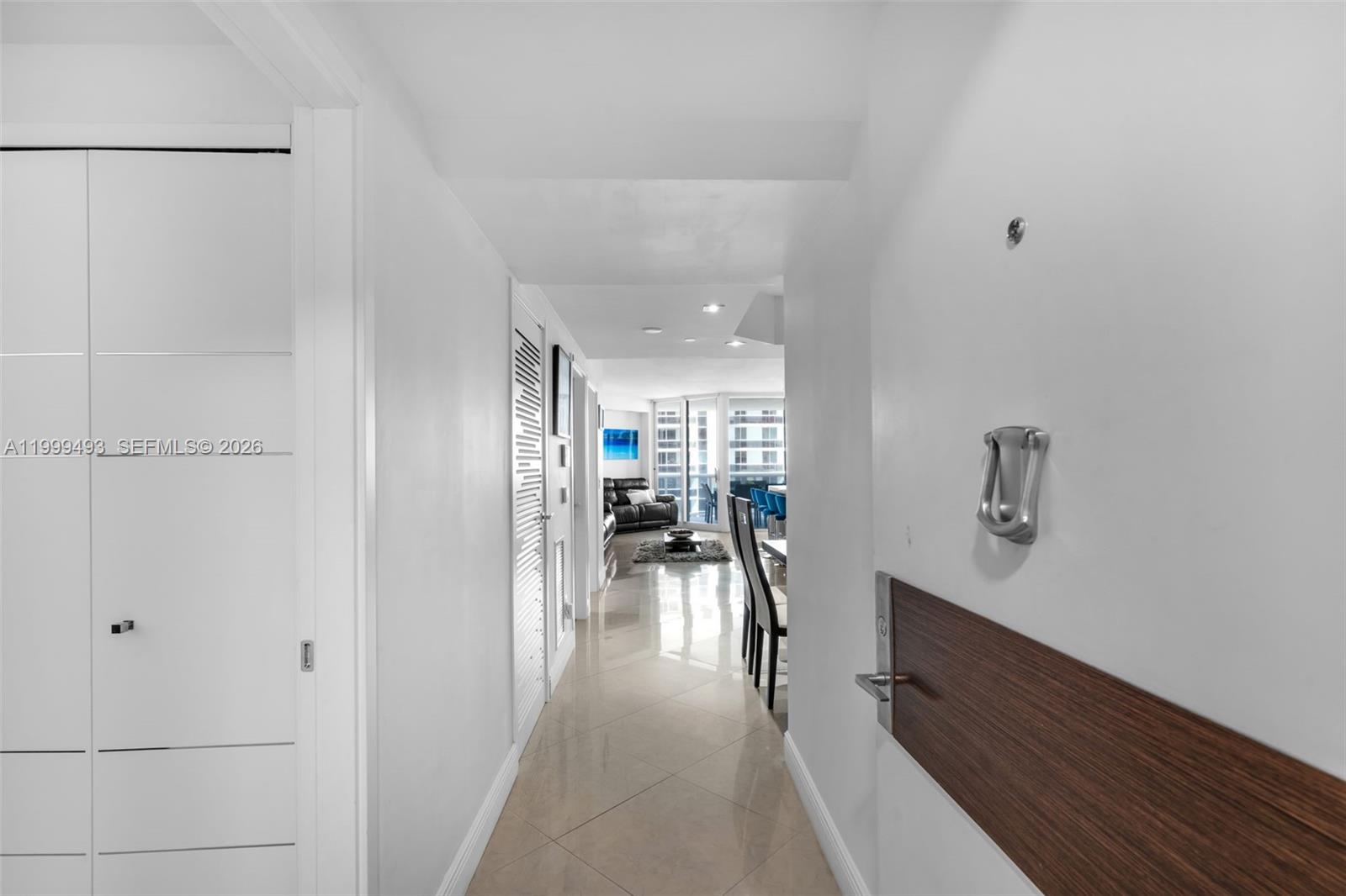 A hallway with tile flooring leads from an entryway toward a bright living area — 4775 Collins Ave # 3608, Miami Beach FL 33140, MIAMI BEACH, FL
