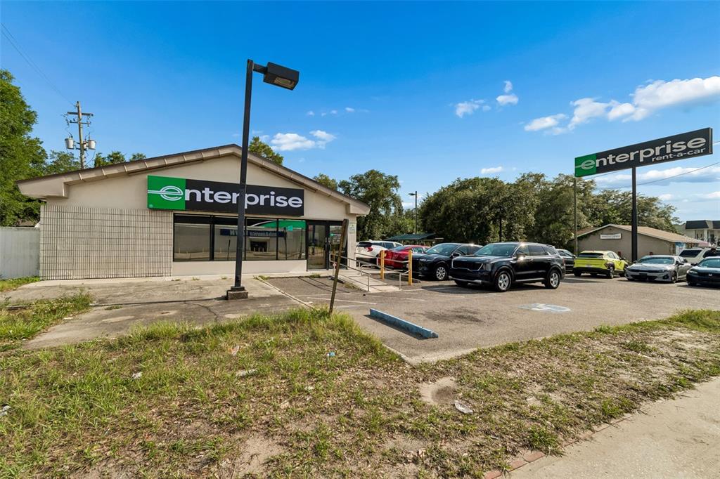 An Enterprise Rent-A-Car building with a parking lot and signage under a blue sky — 4901 E BUSCH BOULEVARD, TAMPA, FL