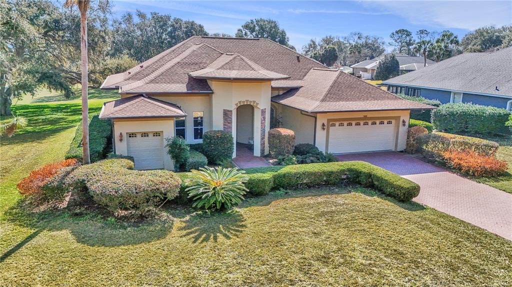 An aerial view of a single-story house with a two-car garage and landscaped front yard — 39644 HARBOR HILLS BOULEVARD, LADY LAKE, FL