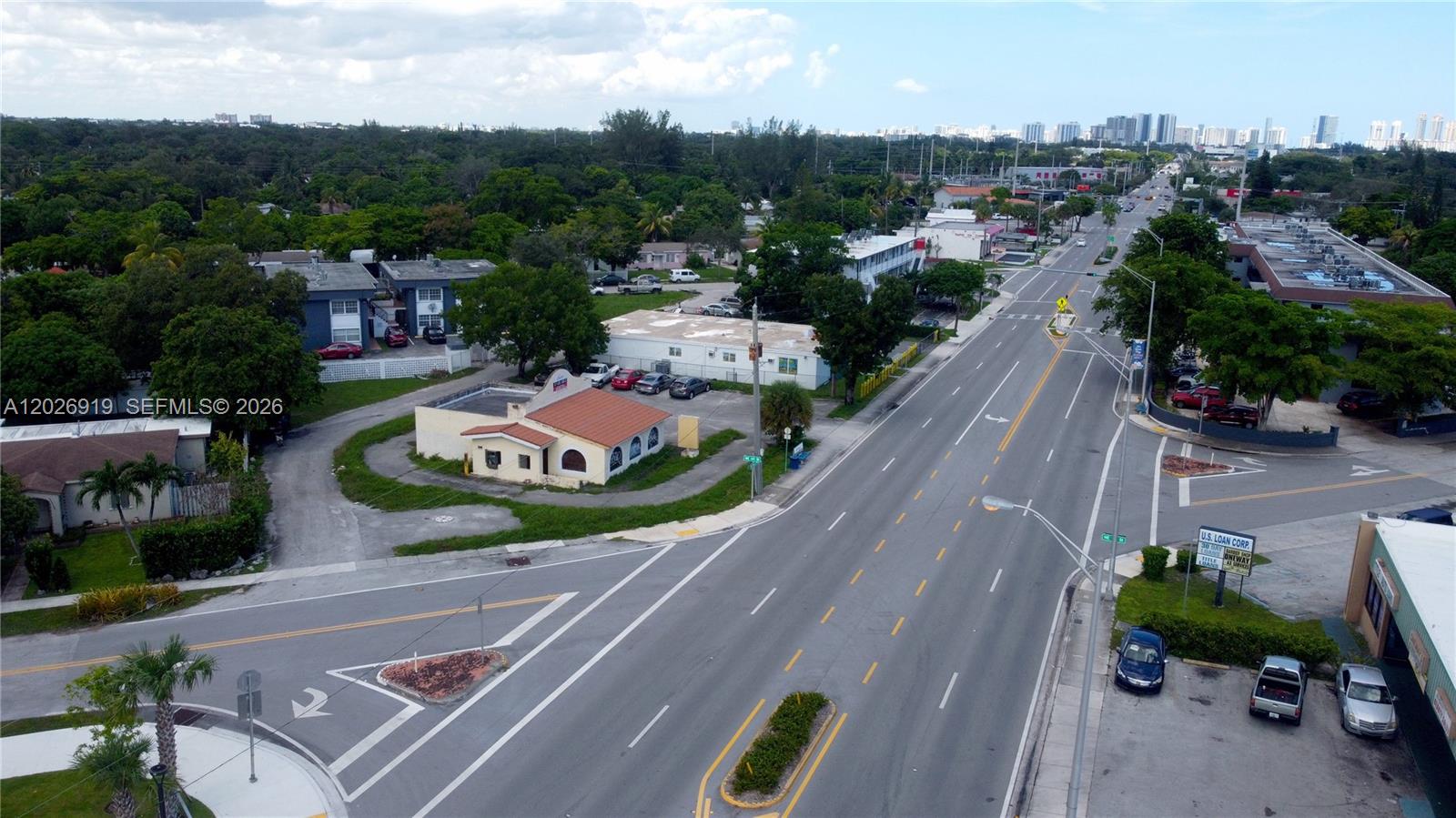 An aerial view shows a commercial building with a red roof beside a multi-lane road — 14100 W Dixie Hwy, North Miami FL 33161, NORTH MIAMI, FL