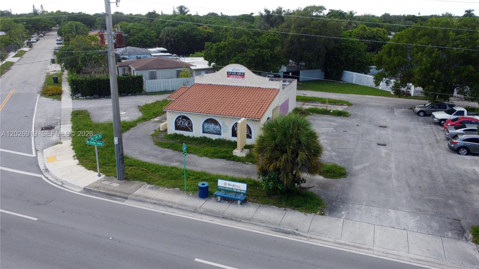 An aerial view shows a small commercial building with a red tile roof and parking lot — 14100 W Dixie Hwy, North Miami FL 33161, NORTH MIAMI, FL
