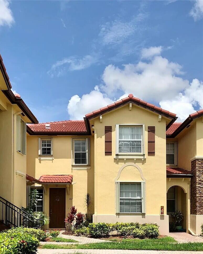 A two-story yellow stucco townhouse with a red tile roof and brown shutters — 1655 NE 33rd Road # 4, Homestead FL 33033, HOMESTEAD, FL