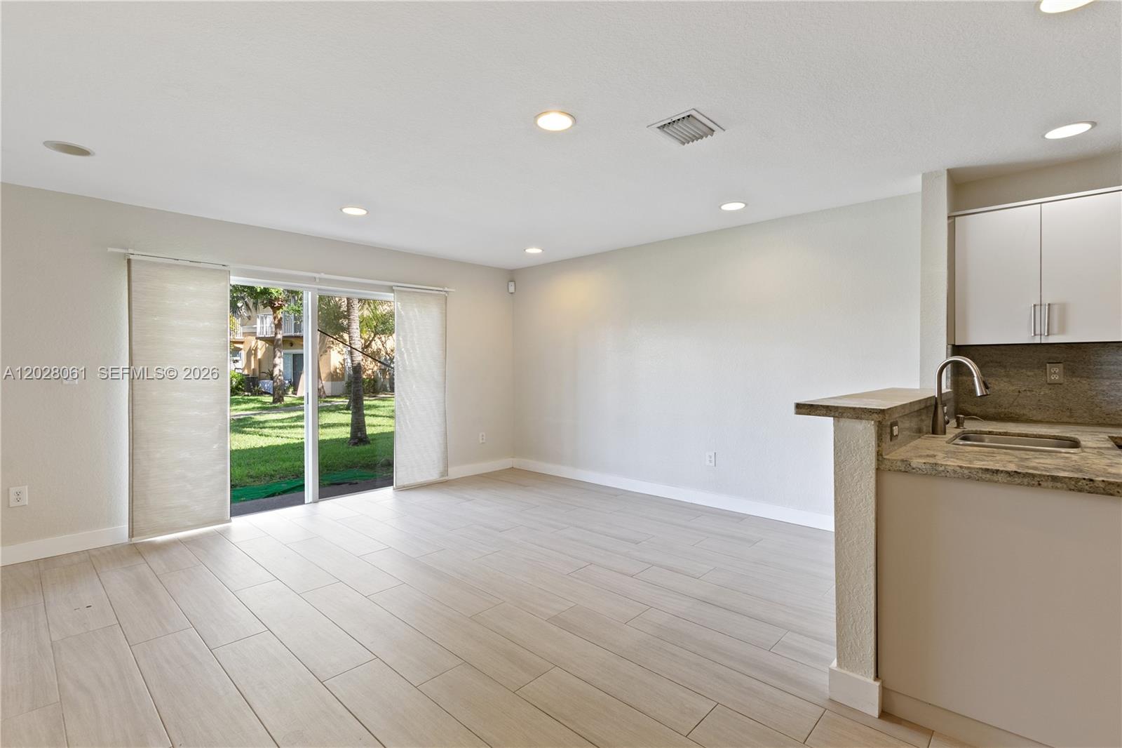 This room features light-colored tile flooring, recessed lighting, and a sliding glass door to outside — 3126 SW 128th Ave # 157, Miramar FL 33027, MIRAMAR, FL