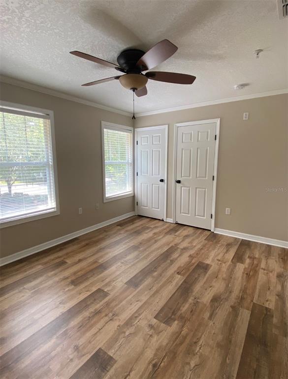 A kitchen features white cabinets, a dark gray island with a white countertop, and tile flooring — 4574 SW 48TH WAY UNIT 103, GAINESVILLE, FL