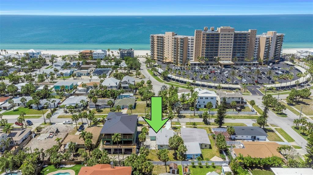 An aerial view shows a single-story house with a green arrow pointing toward its roof — 875 BRUCE AVENUE, CLEARWATER, FL